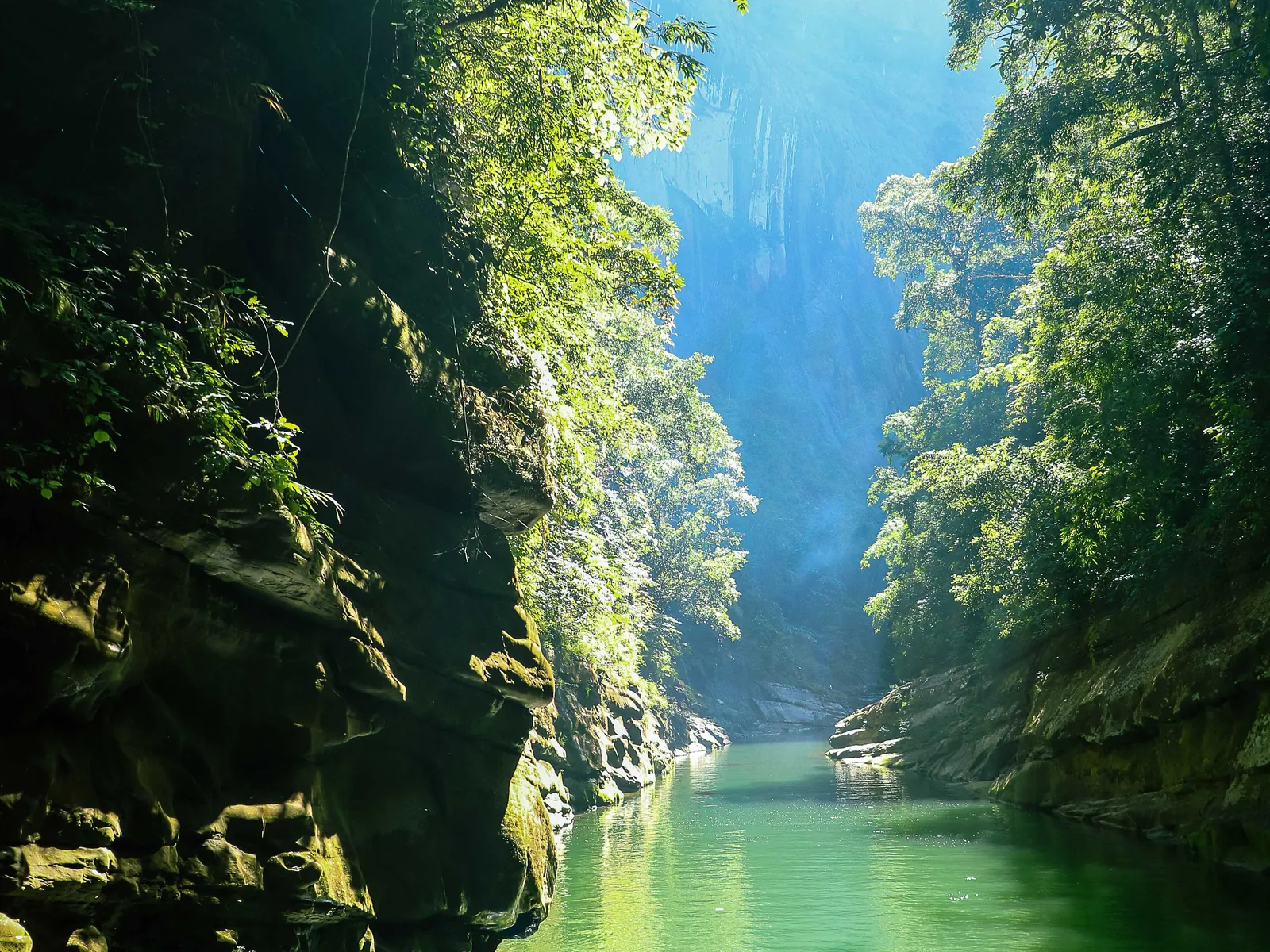 A boat in an emerald gorge between cliffs in Bandarban